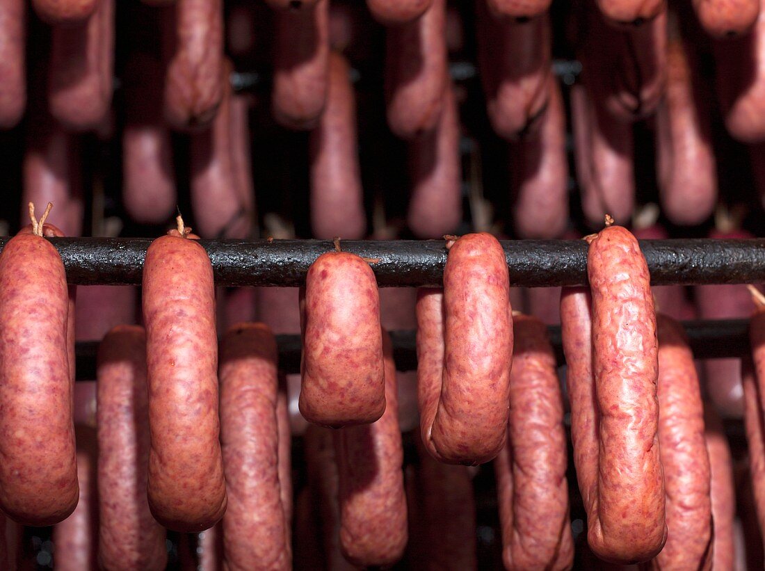 Sausages hanging in a smoking chamber