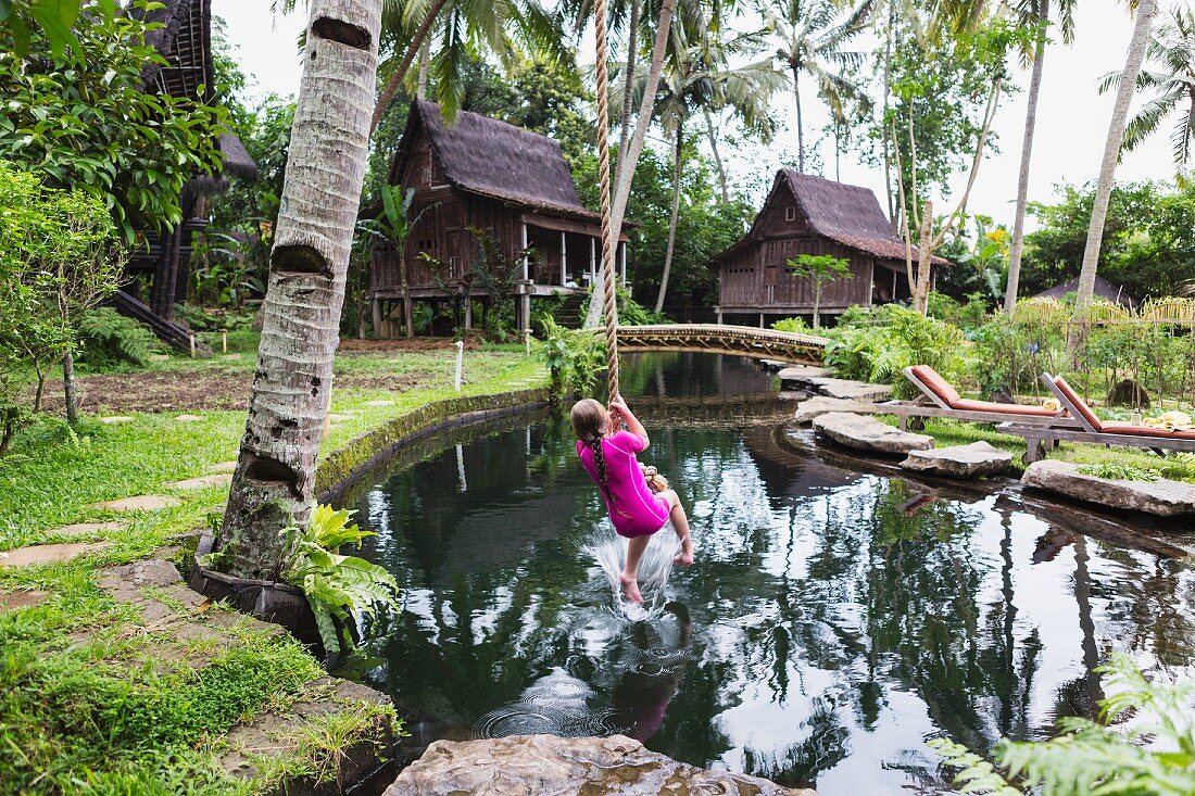 Girl swinging on rope in garden (Ubud, Bali, Indonesia)