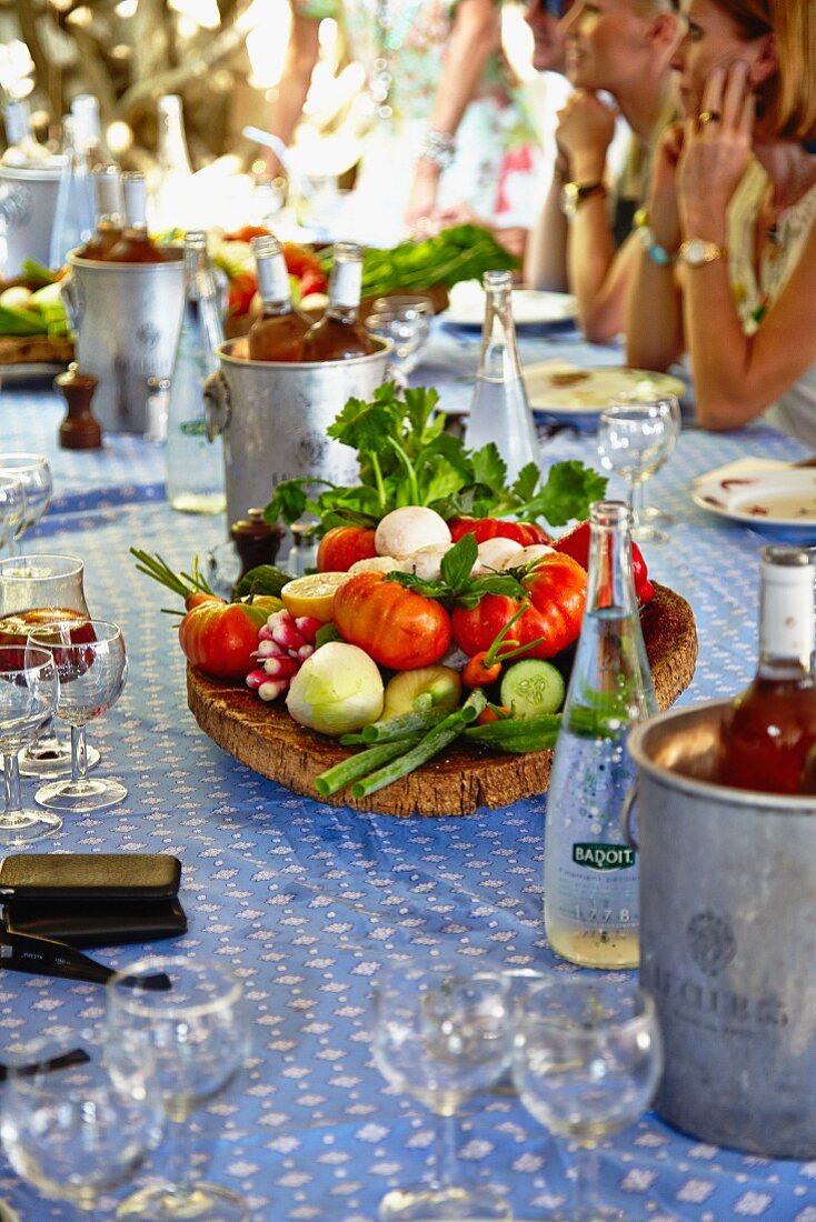 A platter of fresh vegetables on a table laid outside