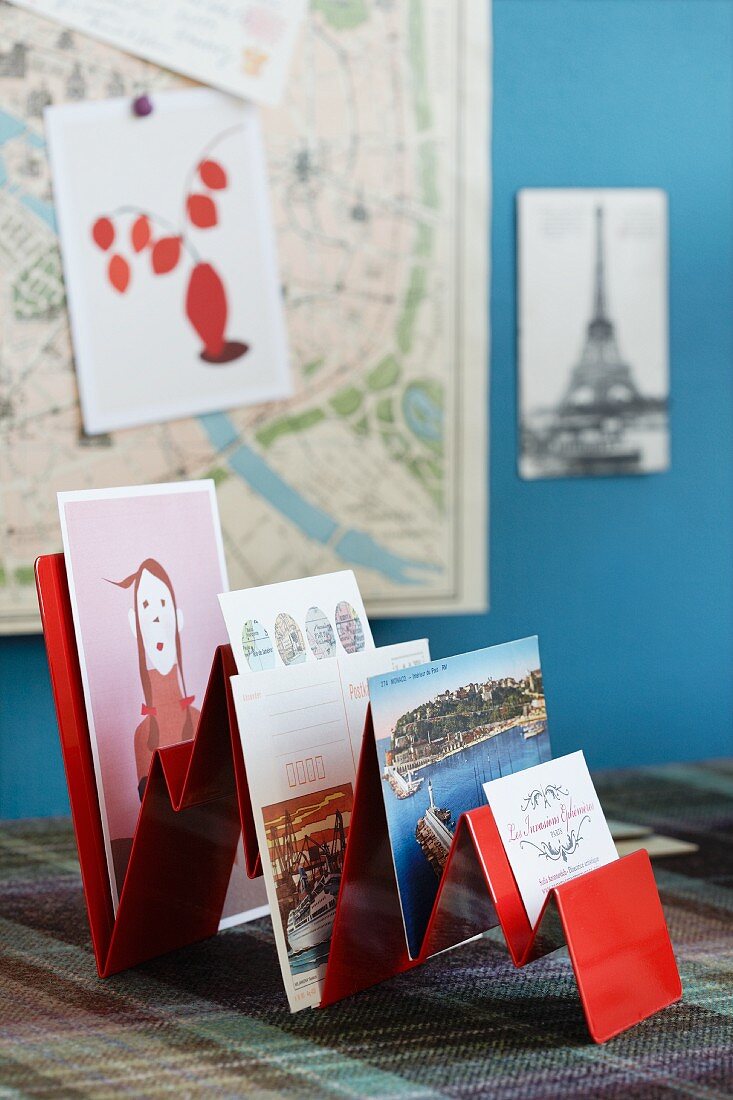 Various postcards in red-painted rack