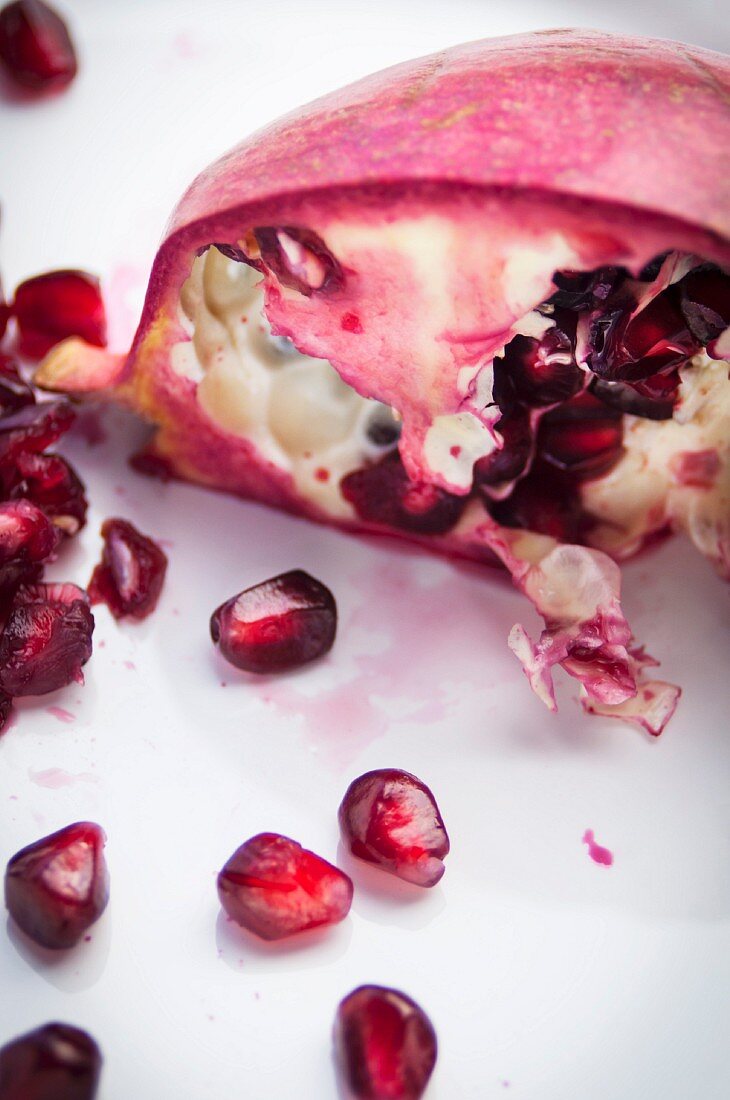 A sliced pomegranate with seeds and juice