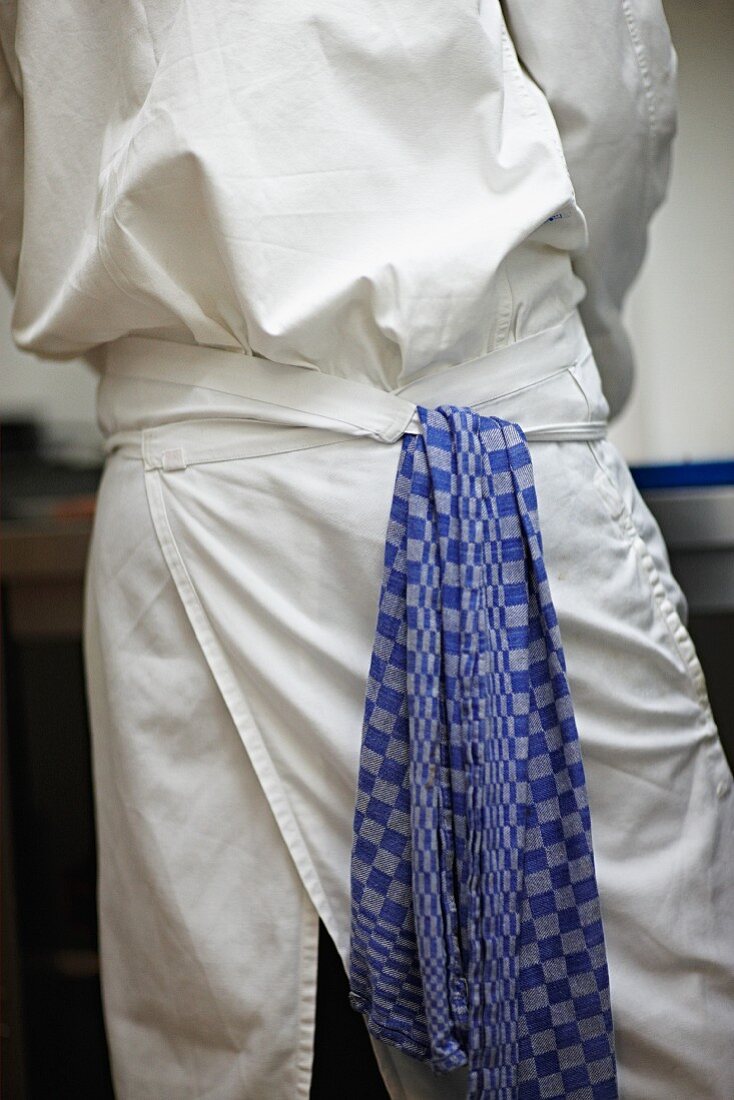 A chef with a tea towel hanging from his apron