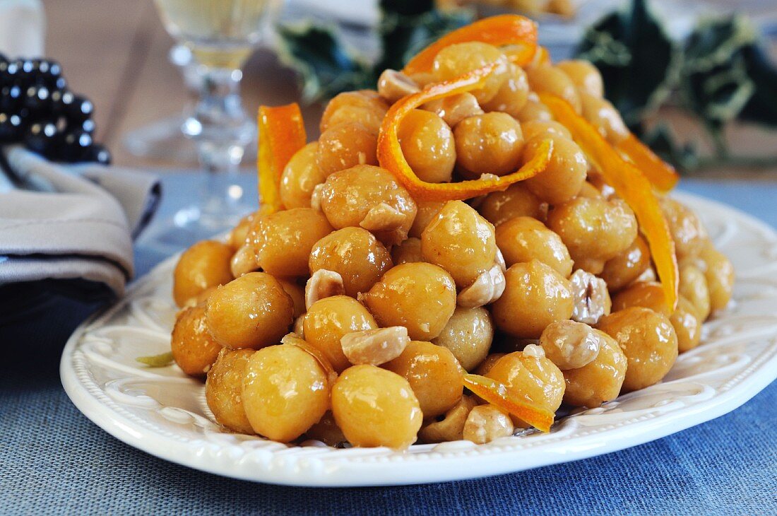 Stuffoli (fried dough balls dipped in honey with candied orange zest and hazelnuts, Italy)