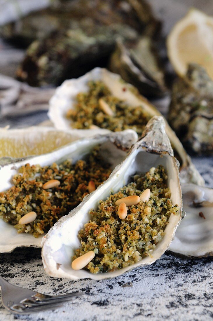 Grilled oysters with a herb crust and pine nuts
