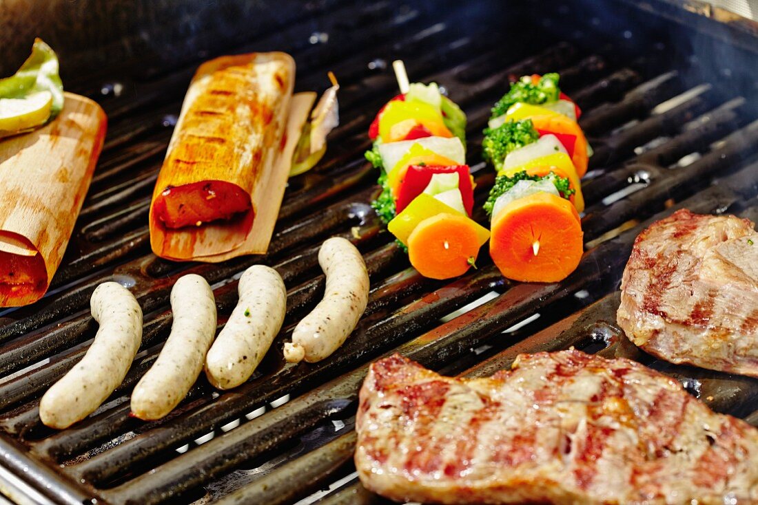 Pork chops, sausages, kebabs and salmon on a barbecue