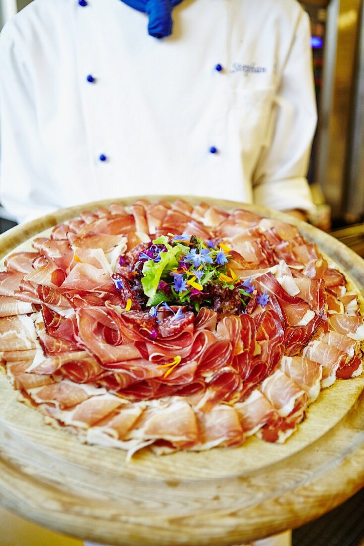 A chef serving a ham platter