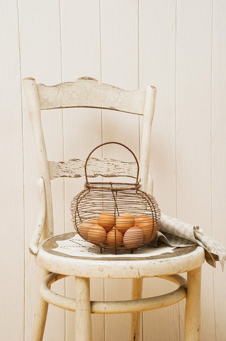 Eggs in a wire basket on an old-fashioned chair