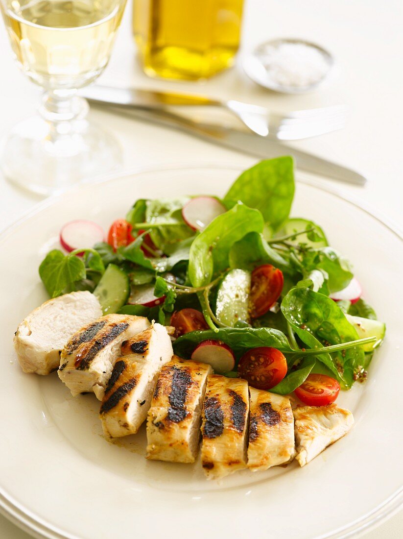 Grilled chicken breast with a spinach, radish and tomato salad