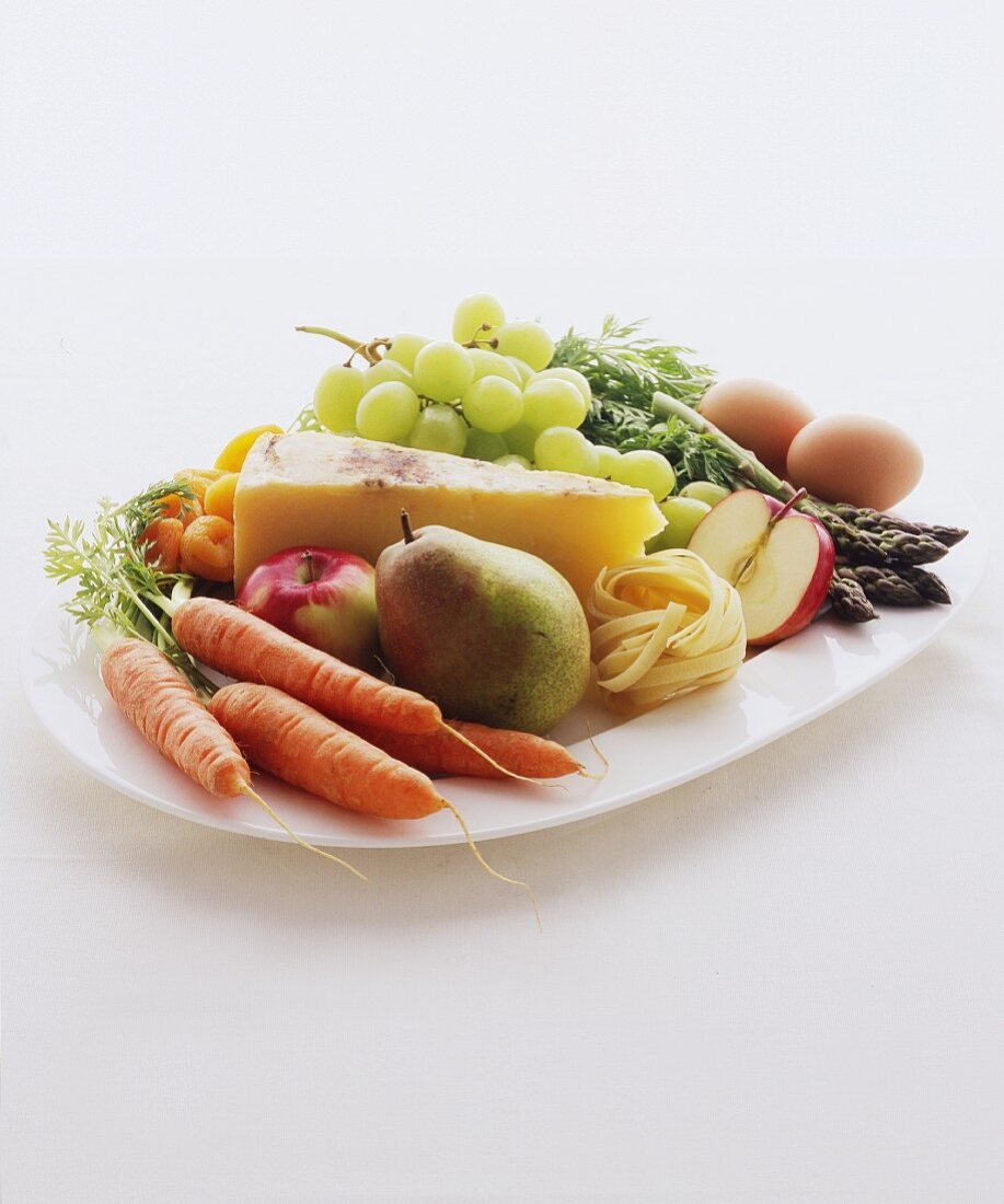 Servierplatte mit Gemüse, Obst, Käse, Nudeln und Eiern