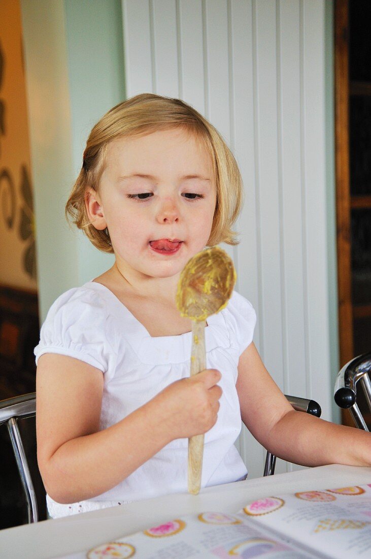 A little girl baking in a kitchen