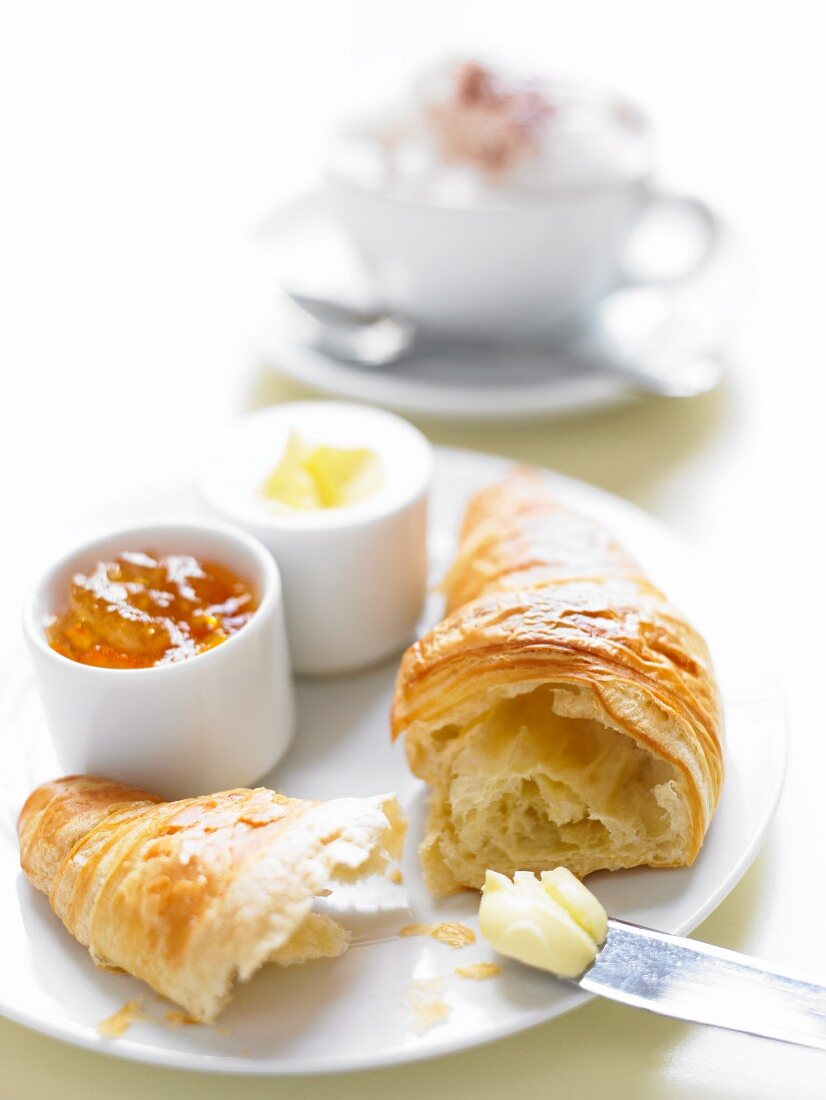 Frisches Croissant mit Butter und Marmelade