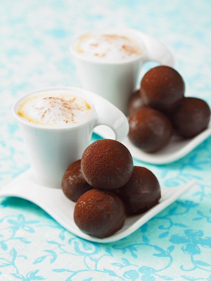 Two cappuccinos served with chocolate pralines