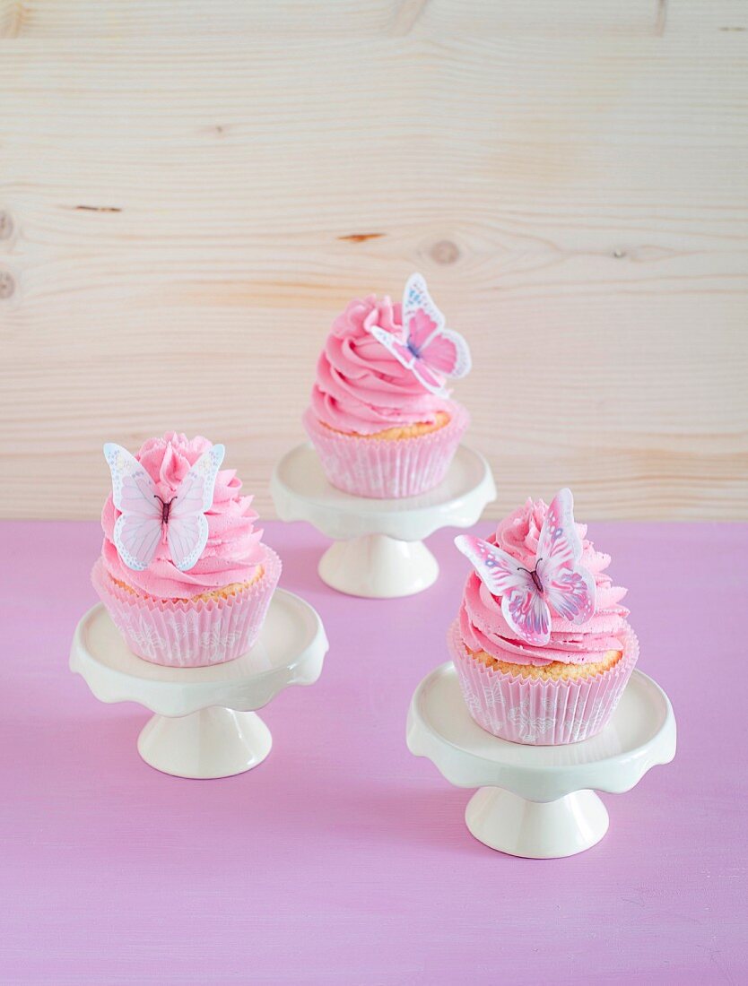 Romantische Cupcakes mit rosa Buttercreme und Schmetterling