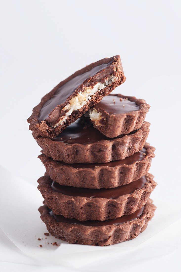 A stack of chocolate tartlets with a coconut filling
