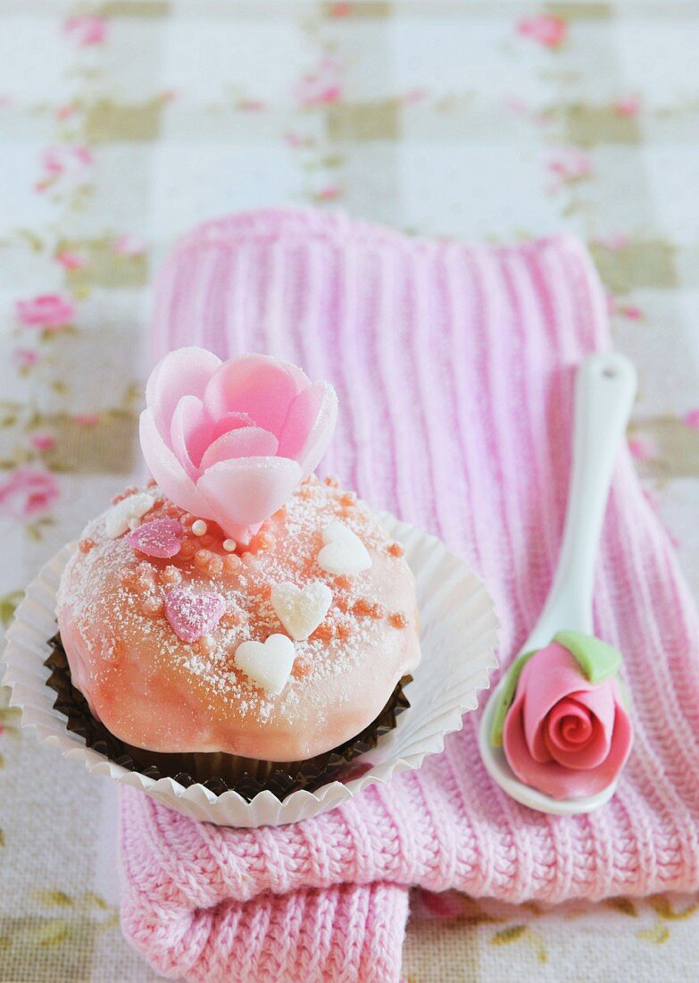 A chocolate cupcake decorated with pink buttercream and sugar roses