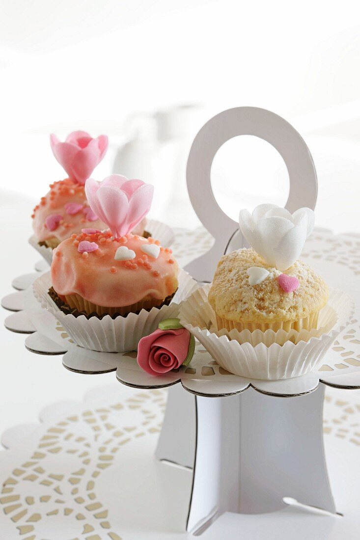 Drei romantische Cupcakes auf Kuchenplatte