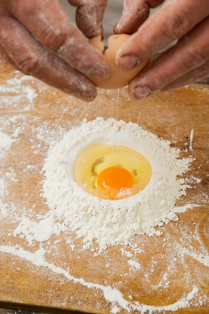 Ei in Mehl aufschlagen