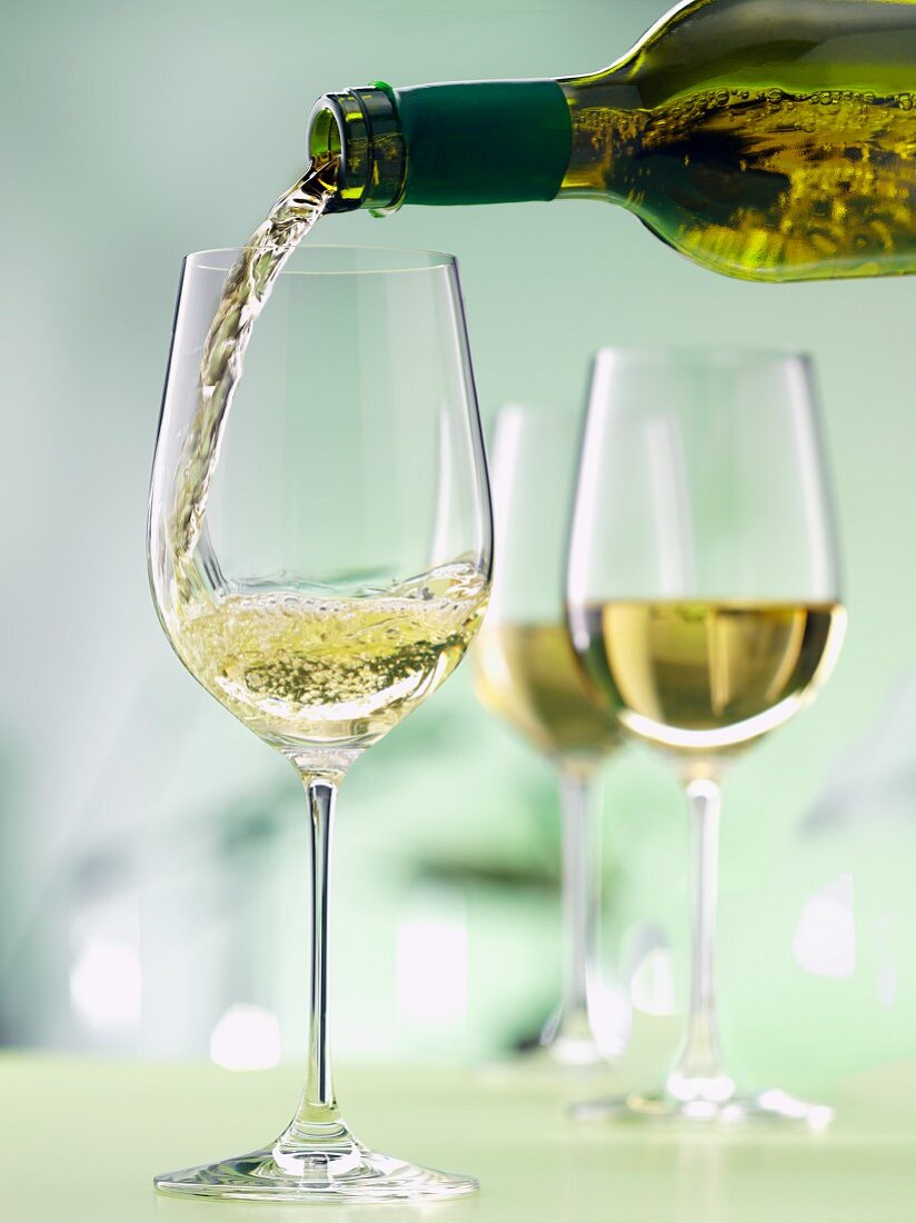 White Wine Pouring from Bottle into a Glass