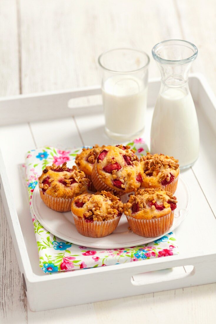 Erdbeer-Müsli-Muffins und Milch auf Tablett