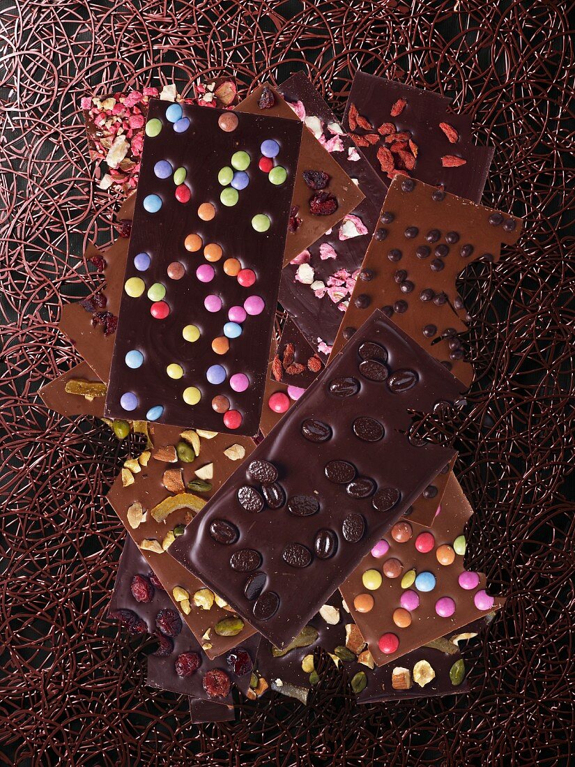 Schokoladentafeln mit bunten Schokolinsen, Pistazien und Mokkabohnen