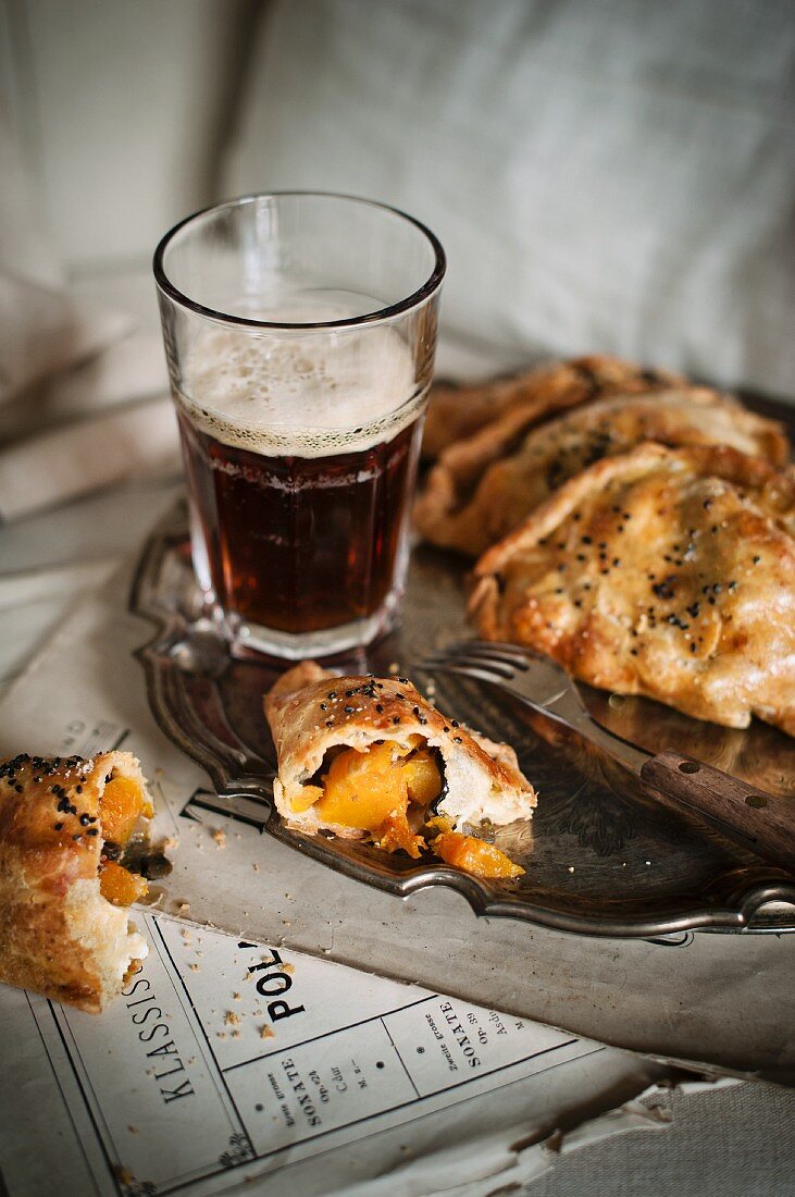 Pasties and a beer on a silver tray