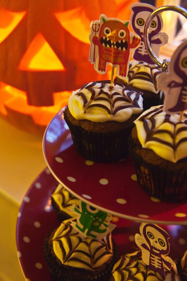 Gruslige Halloween-Cupcakes mit Spinnennetzglasur auf Etagere