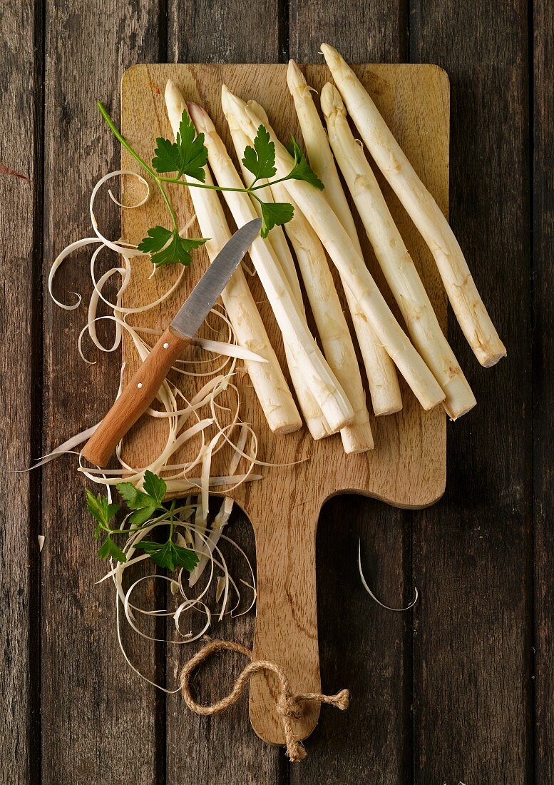 Peeled white asparagus on chopping board