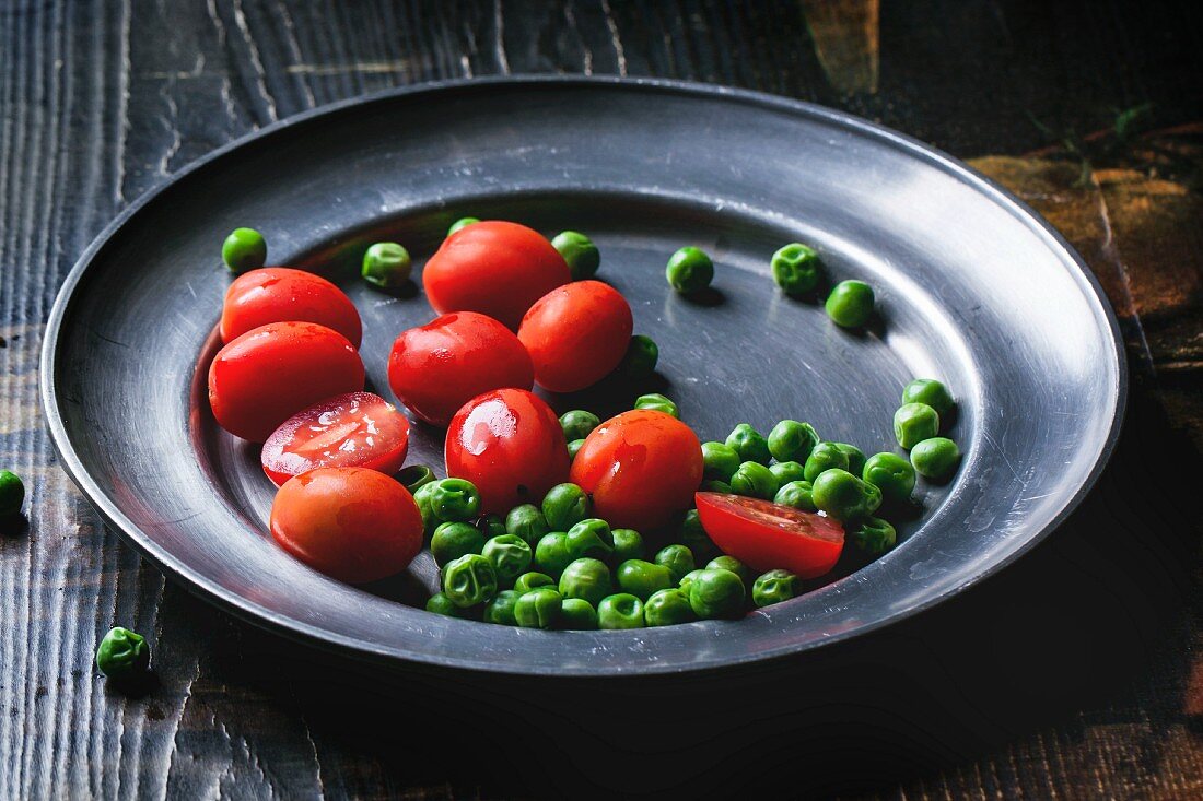 Kirschtomaten und Erbsen auf Metallteller