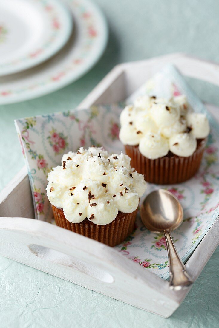 Two chocolate and coconut cupcakes on a floral napkin