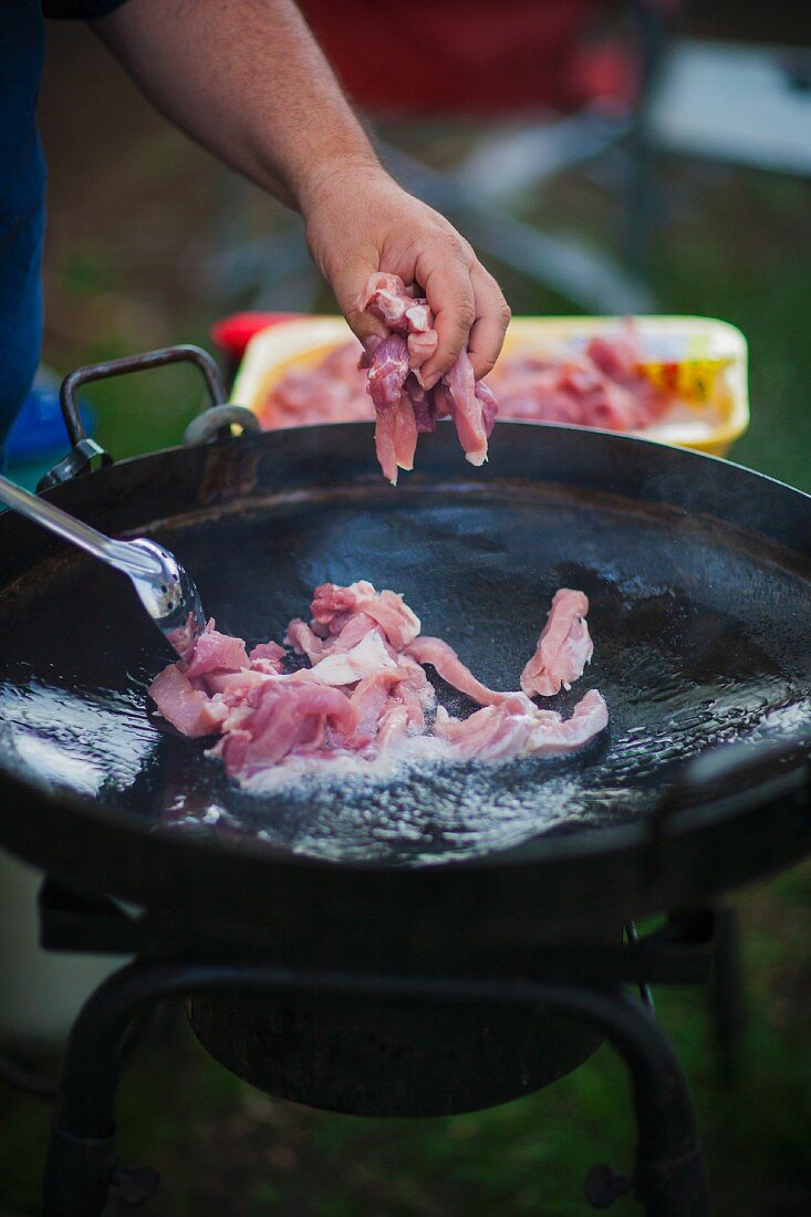 Pork being fried in hot oil for fajitas
