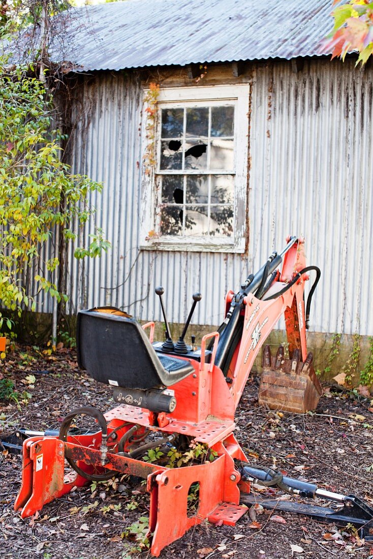 A metal shed and a red digger