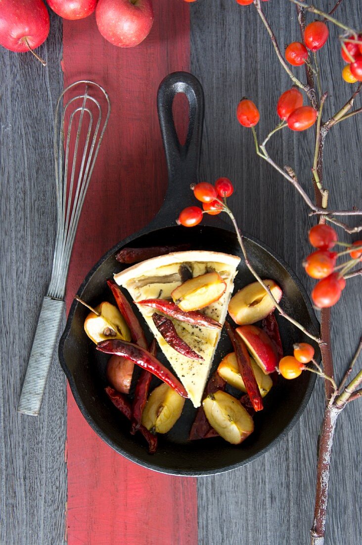 Ein Stück Pilzquiche mit Äpfeln und getrockneten Chilischoten