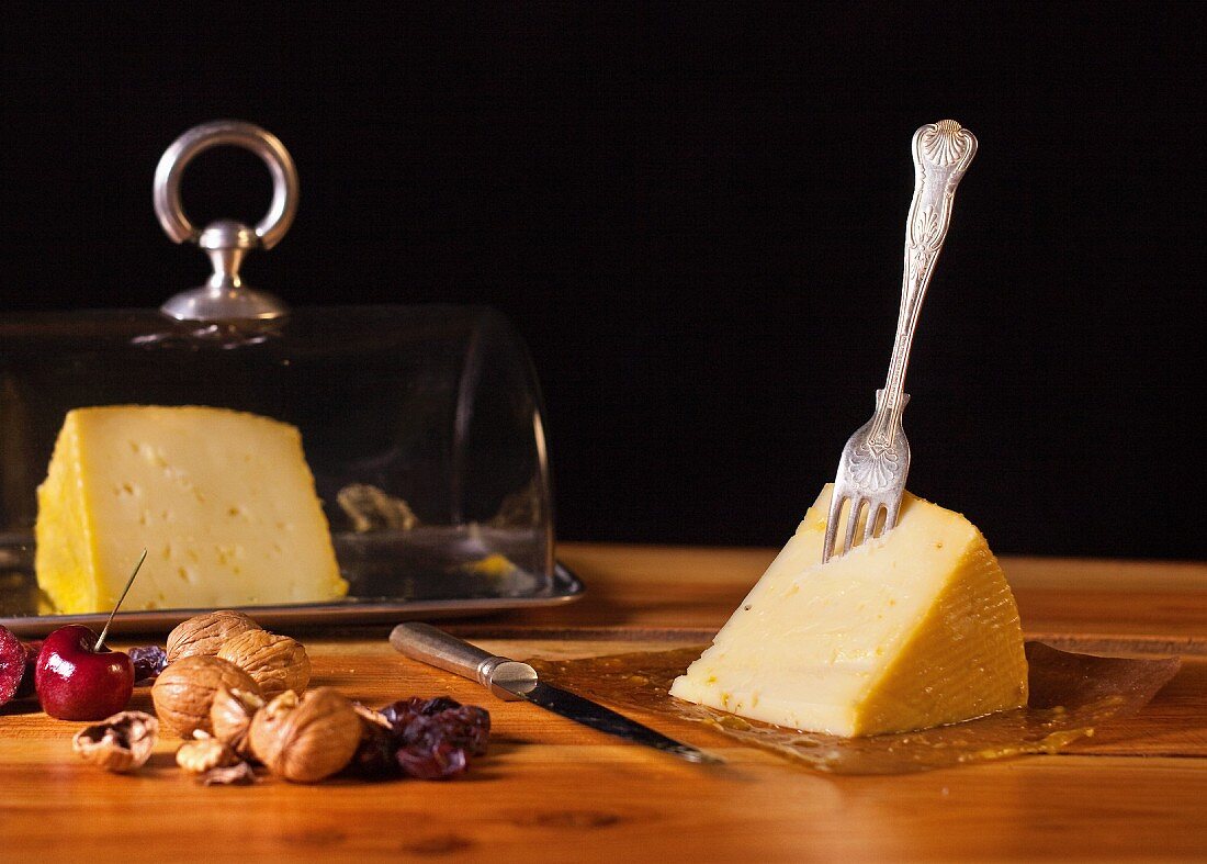 An arrangement of cheese with cherries and walnuts