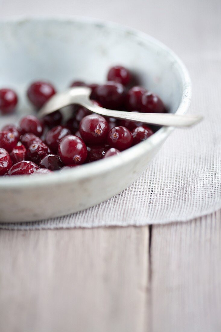 Fresh cranberries in a bowl with a spoon