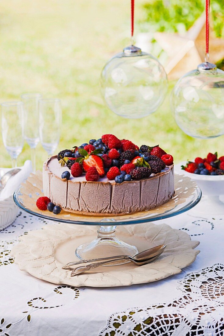 Schokoladeneistorte mit Beeren auf Tisch im Freien