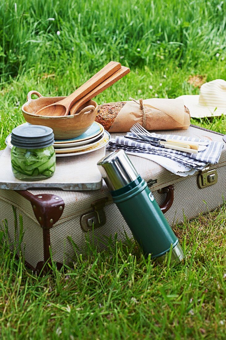 Picknickutensilien, Brot und Salat auf Vintage-Koffer