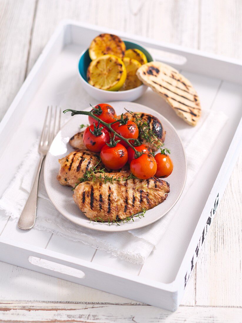 Grilled chicken breast with lemons and tomatoes