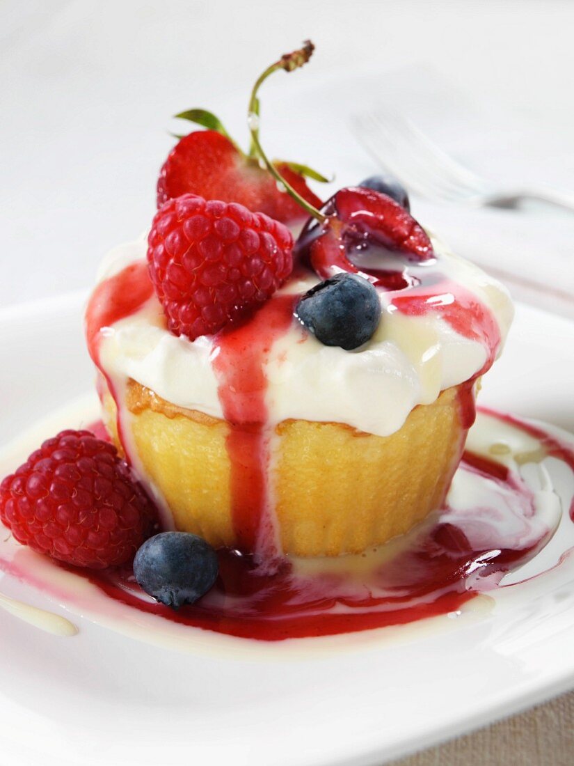 A sponge cake with whipped cream, caramel sauce and fruit