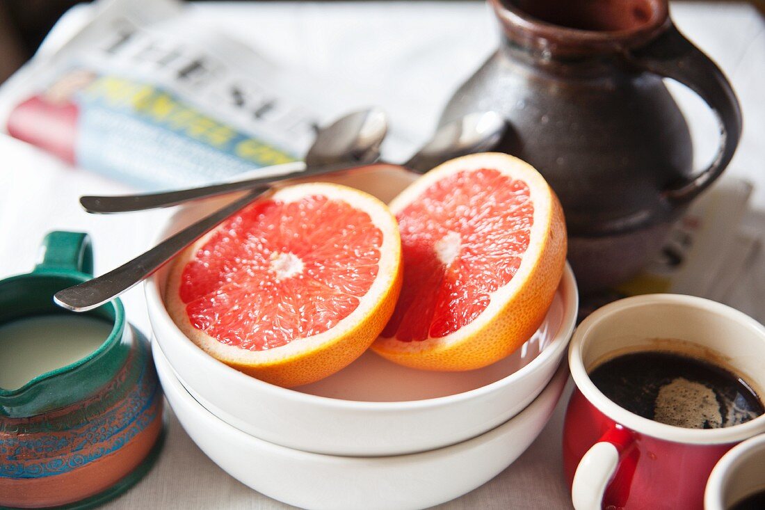 Breakfast with coffee, grapefruit and newspapers