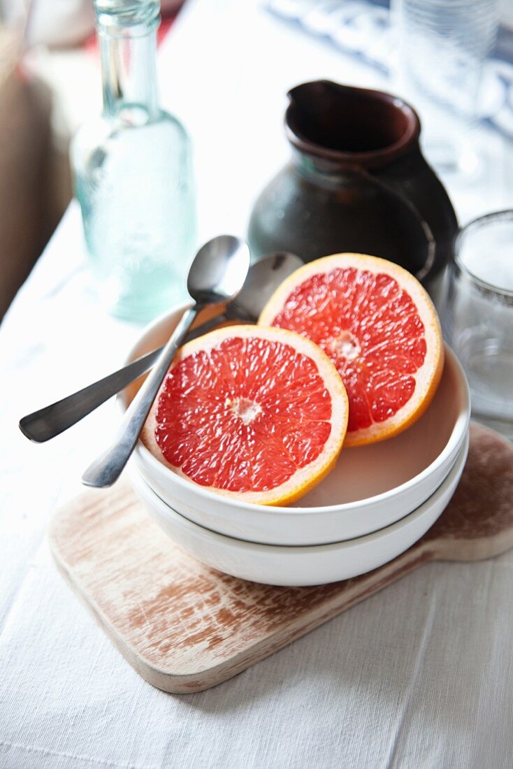 A pink grapefruit and a water jug on a breakfast table
