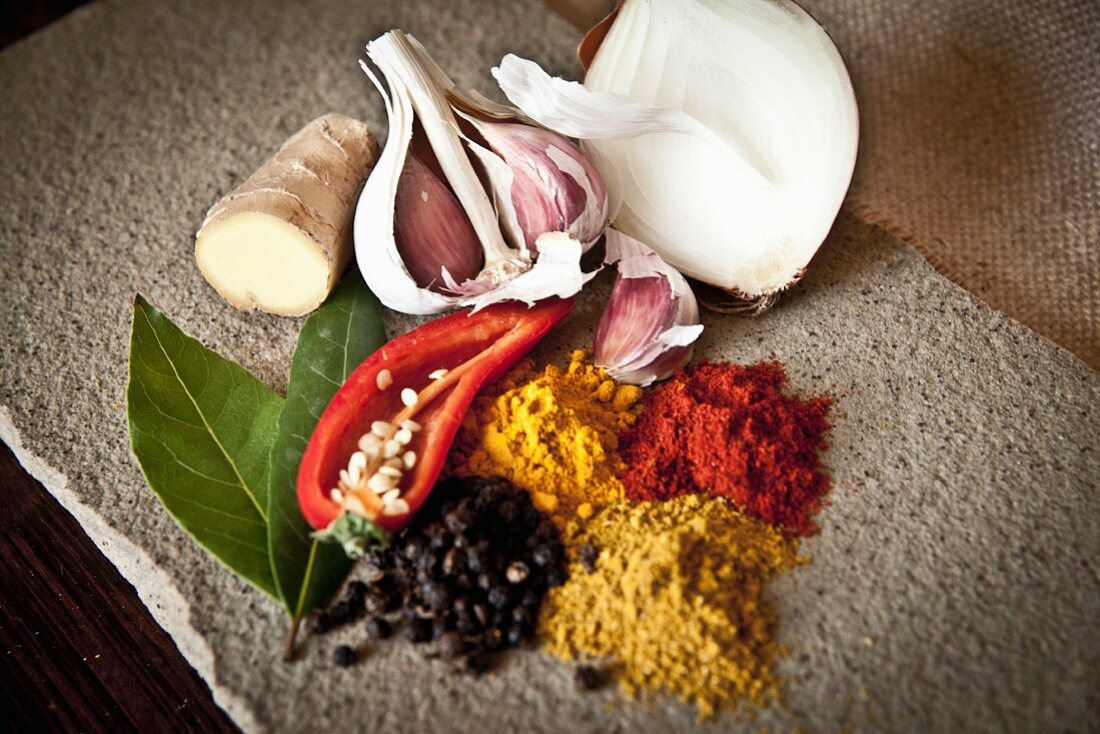 A selection of Indian spices, garlic, onion and chilli peppers