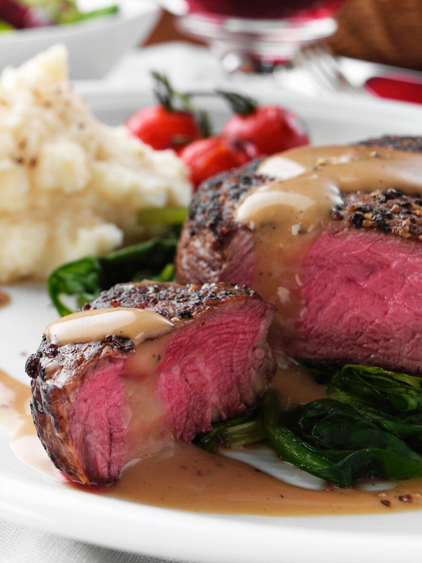 Beef steak on a bed of spinach with celariac puree and tomatoes