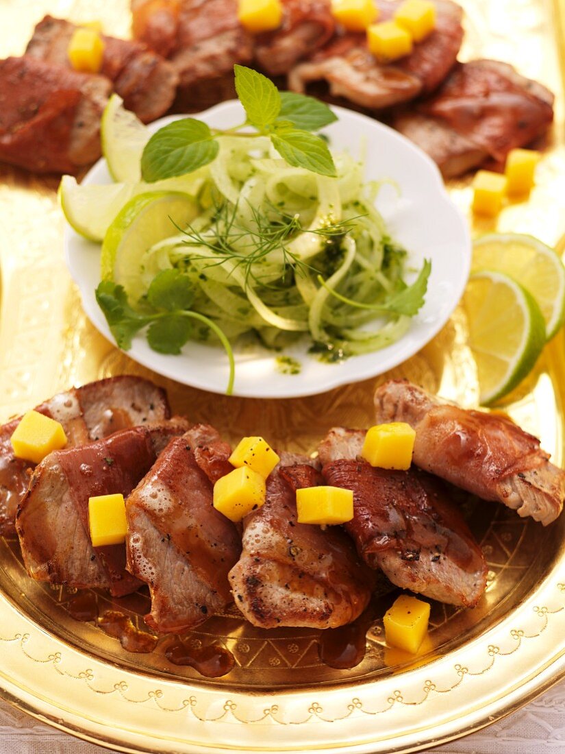 Pork fillet wrapped in ham on an onion and mint salad (India)
