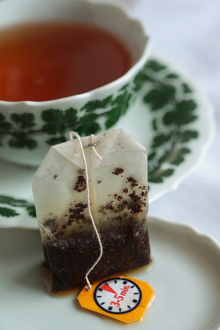 A teabag in front of a tea cup
