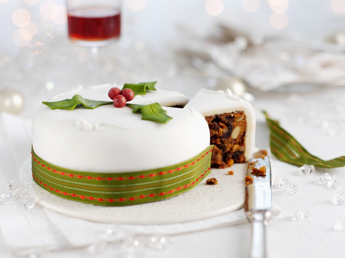 A white Christmas cake with a green ribbon