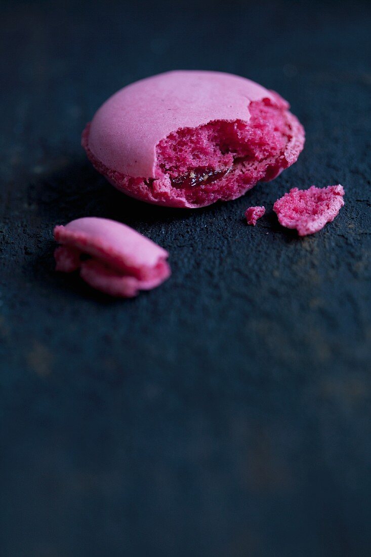 A cranberry macaroon with a bite taken out