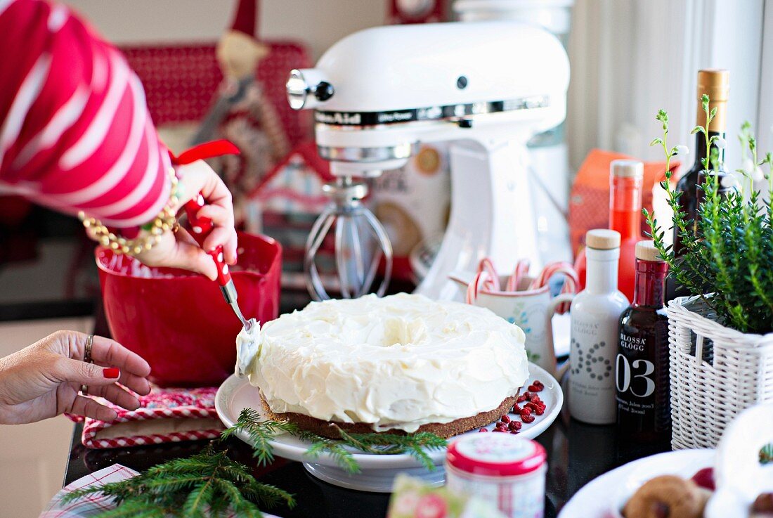 Christmas cake being spread with cream