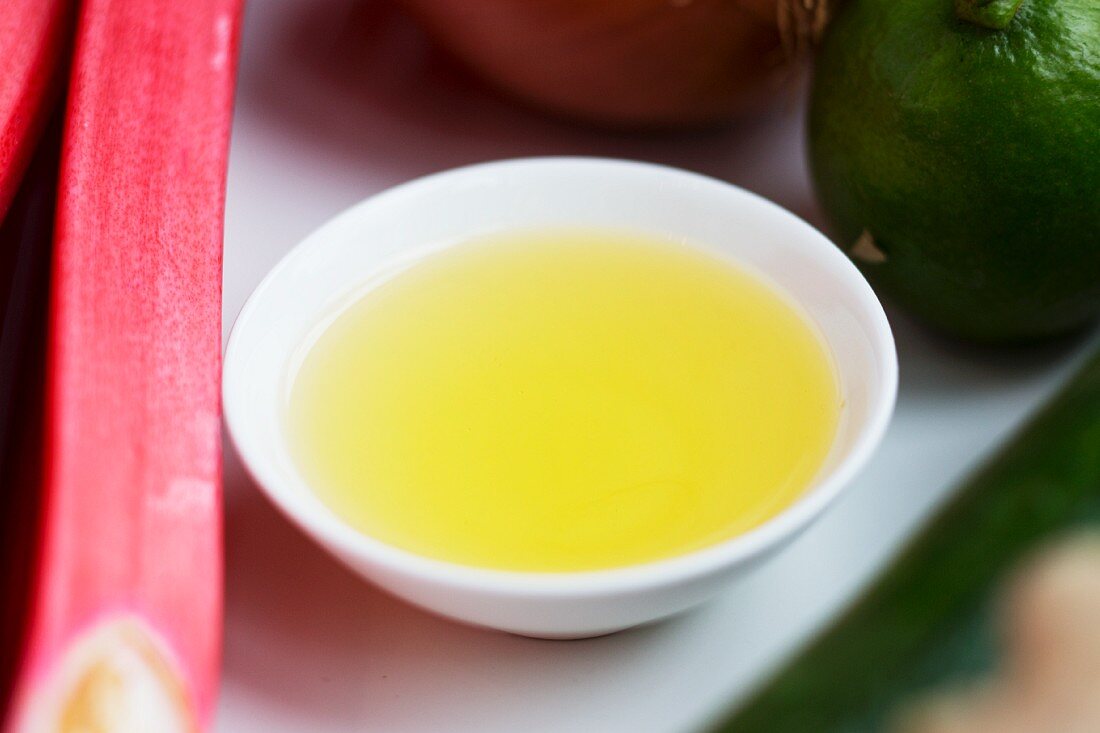 A bowl of oil with rhubarb and limes