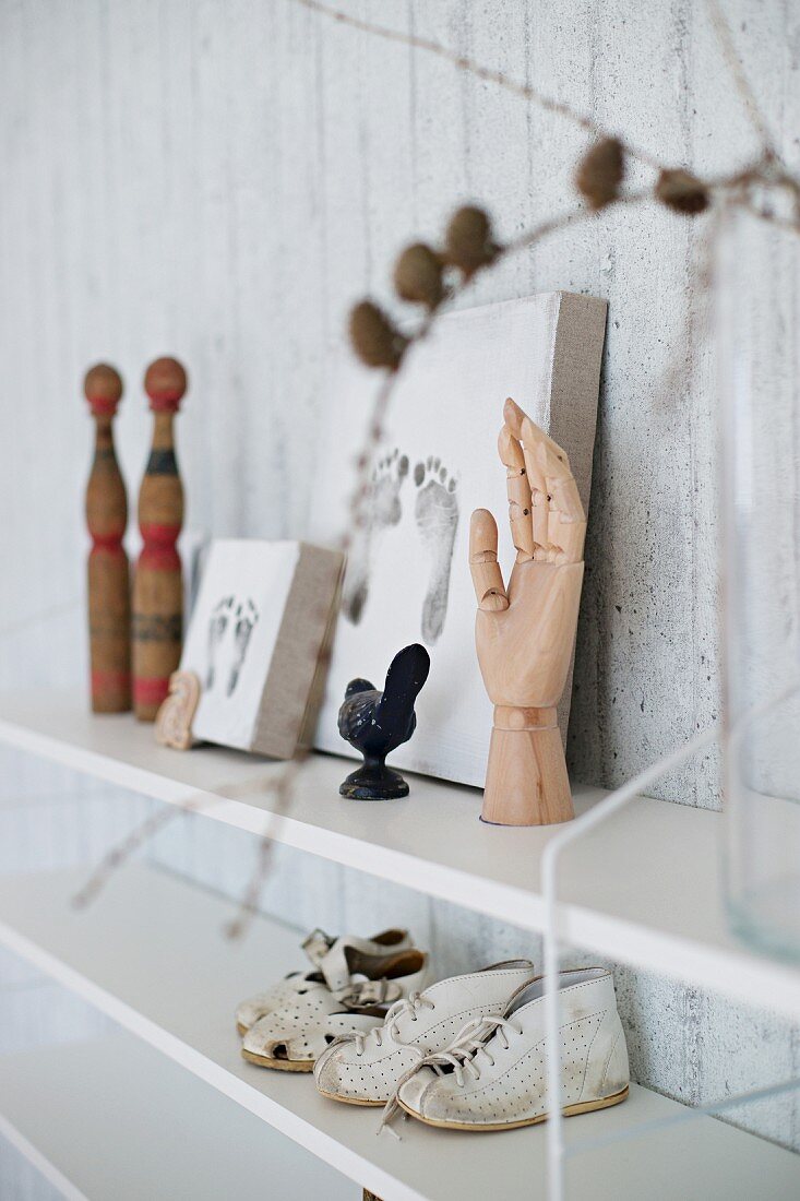 Memorabilia such as framed footprints and booties on shelves on exposed concrete wall