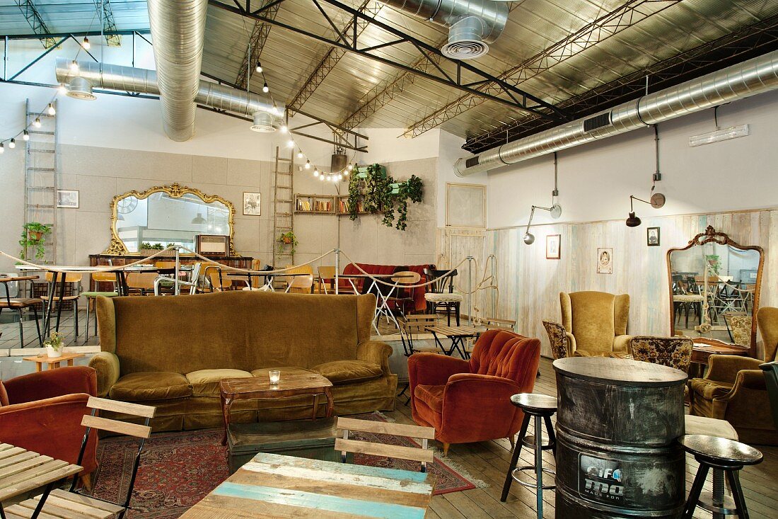 Private club with comfortable, vintage furnishings below metal ceiling in former workshop